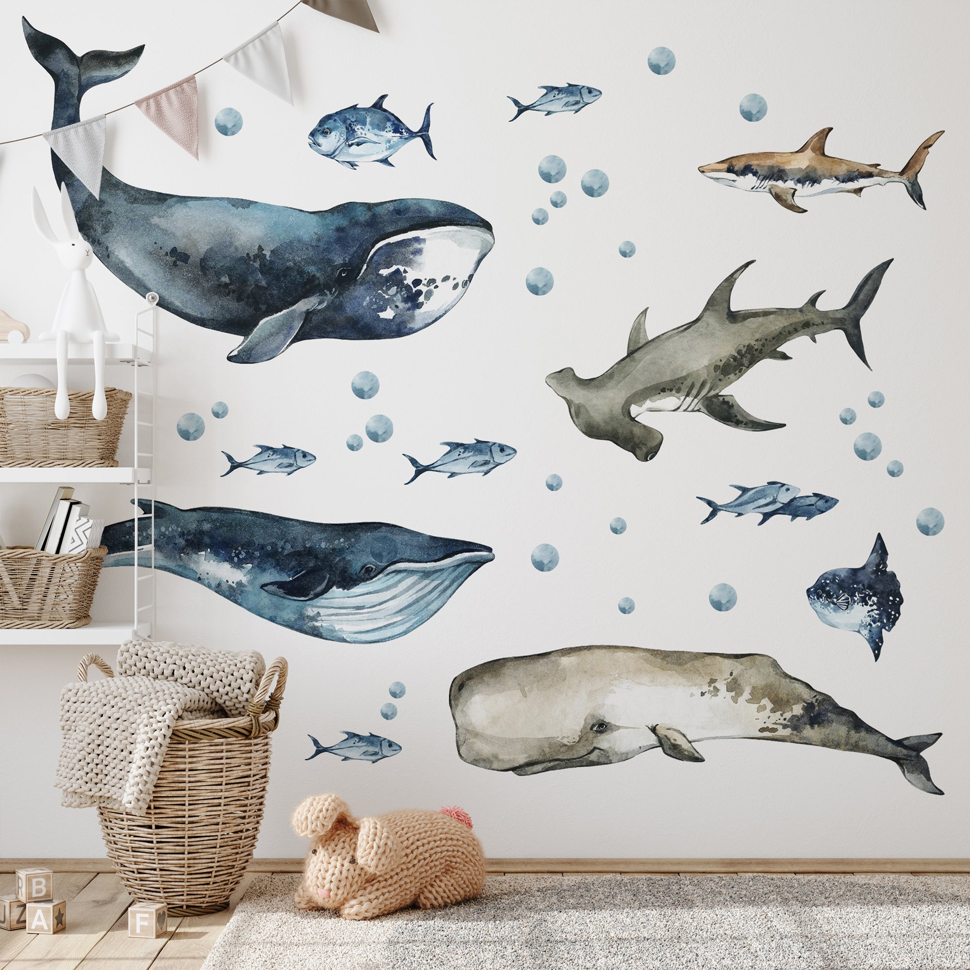 Wall decal of whales, sharks, and fish on a wall with a textured surface.