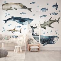 Children's room with whale and shark wall decals on a light-colored floor.