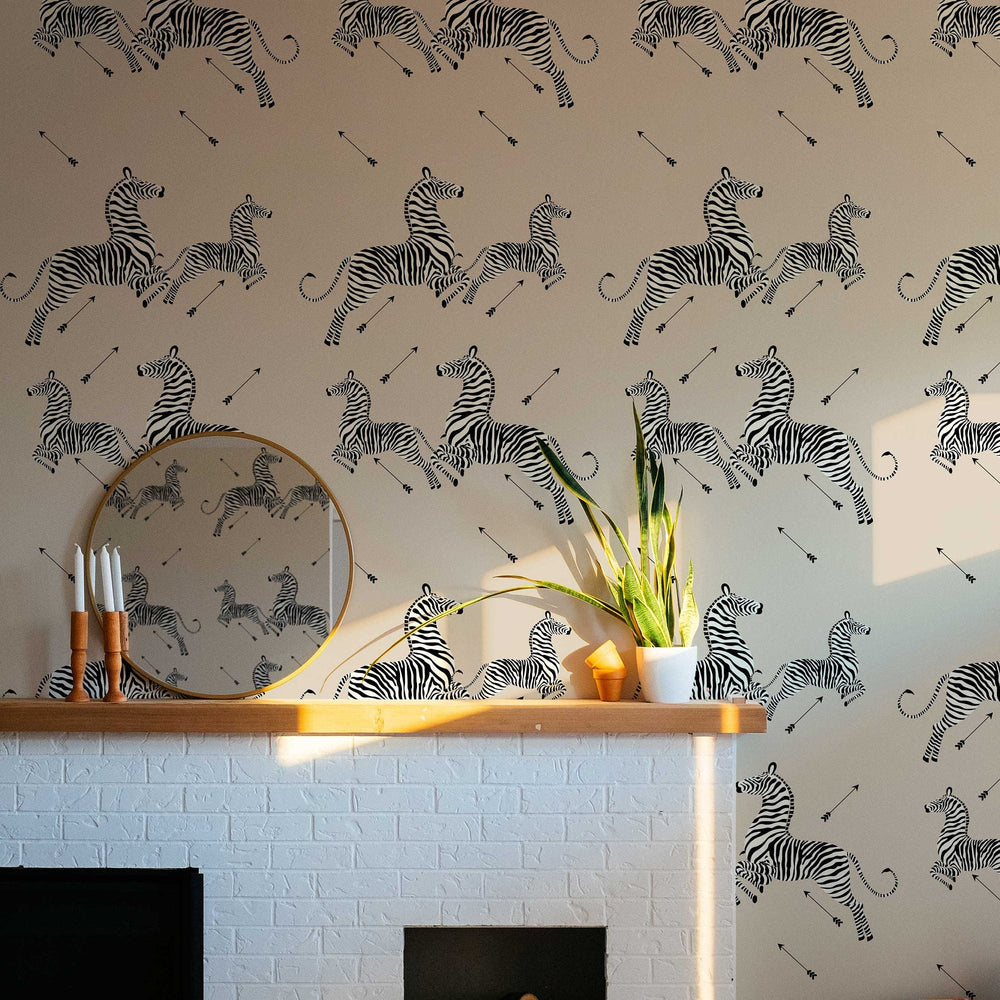 Leaping zebra and arrow wallpaper on a cream background above a fireplace
