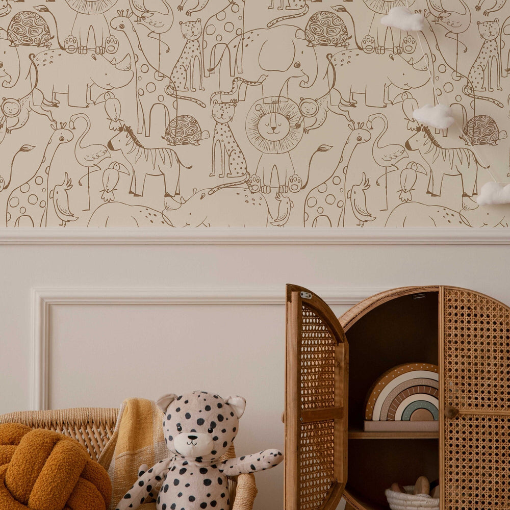 Hand-drawn safari animals wallpaper in brown line on beige, in a nursery with a rattan cabinet