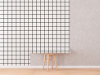 Black and White Grid Wallpaper roll shown against a wall