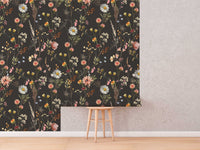 Moody Dark Wildflower Wallpaper roll shown against a wall