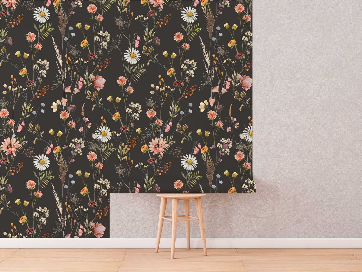 Moody Dark Wildflower Wallpaper roll shown against a wall
