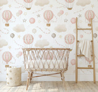 Pink Hot Air Balloon Wallpaper behind a rattan crib