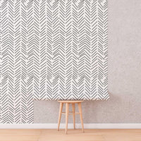 Black and White Herringbone Wallpaper roll shown against a wall