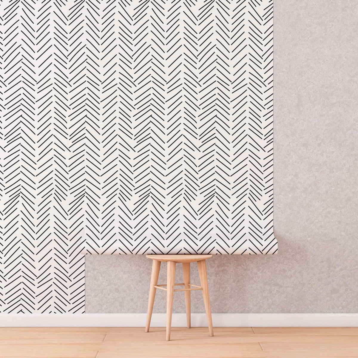 Black and White Herringbone Wallpaper roll shown against a wall