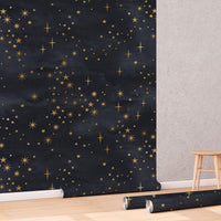 Celestial Starry Night Wallpaper roll shown against a wall